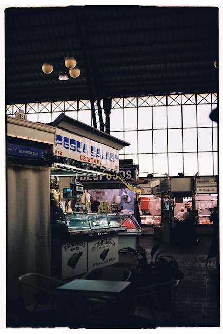 Interior view of a bustling food hall market with vendors and shoppers