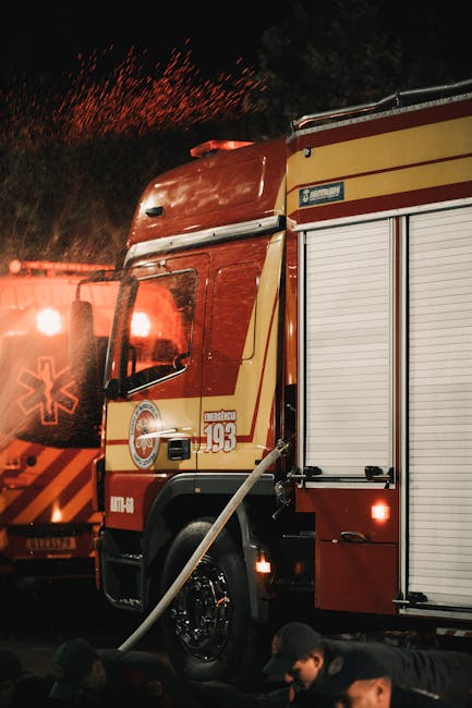 Fire trucks and emergency vehicles on a city street at night