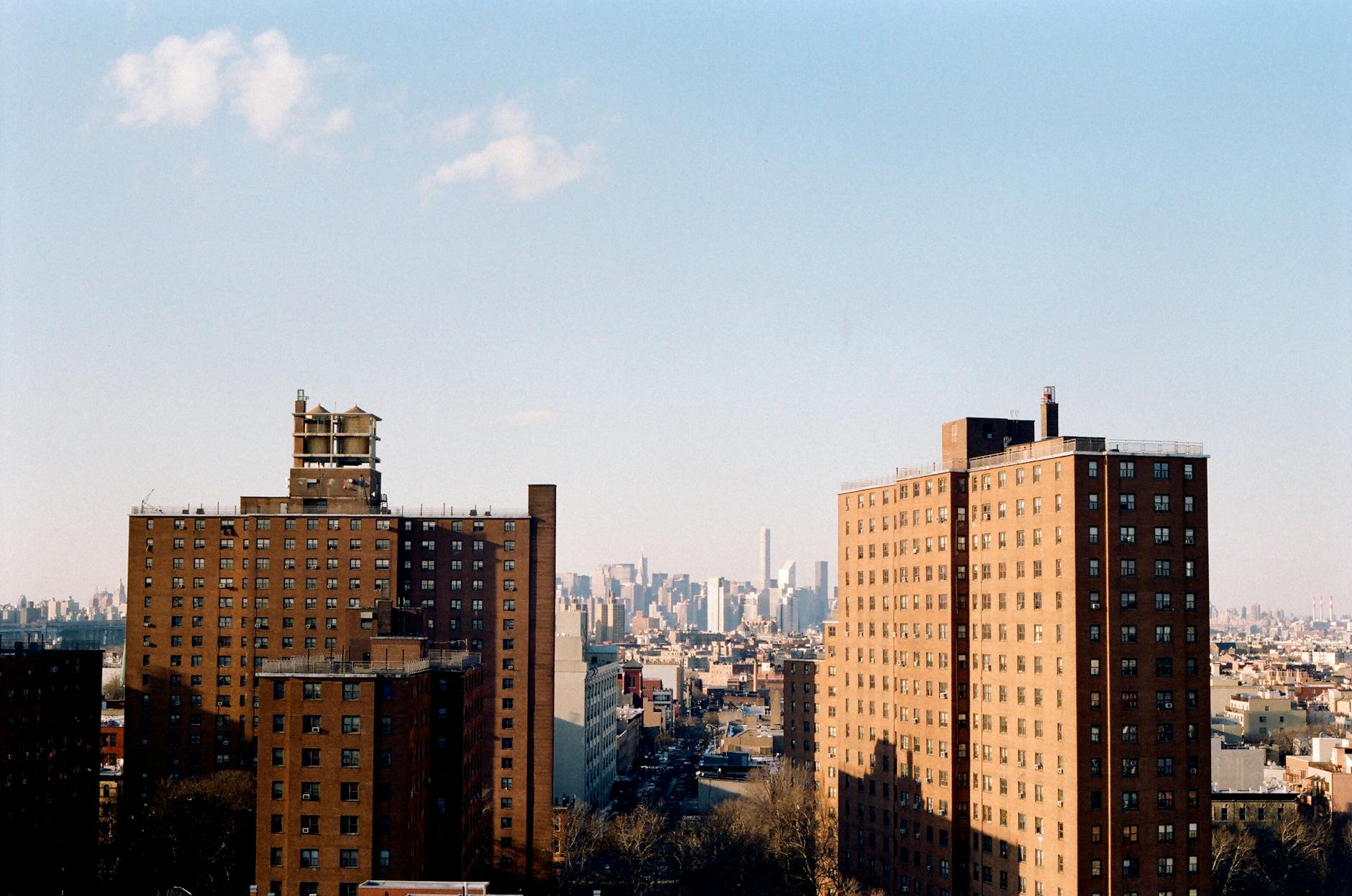 A scenic view of New York apartment buildings with a city skyline in the background.