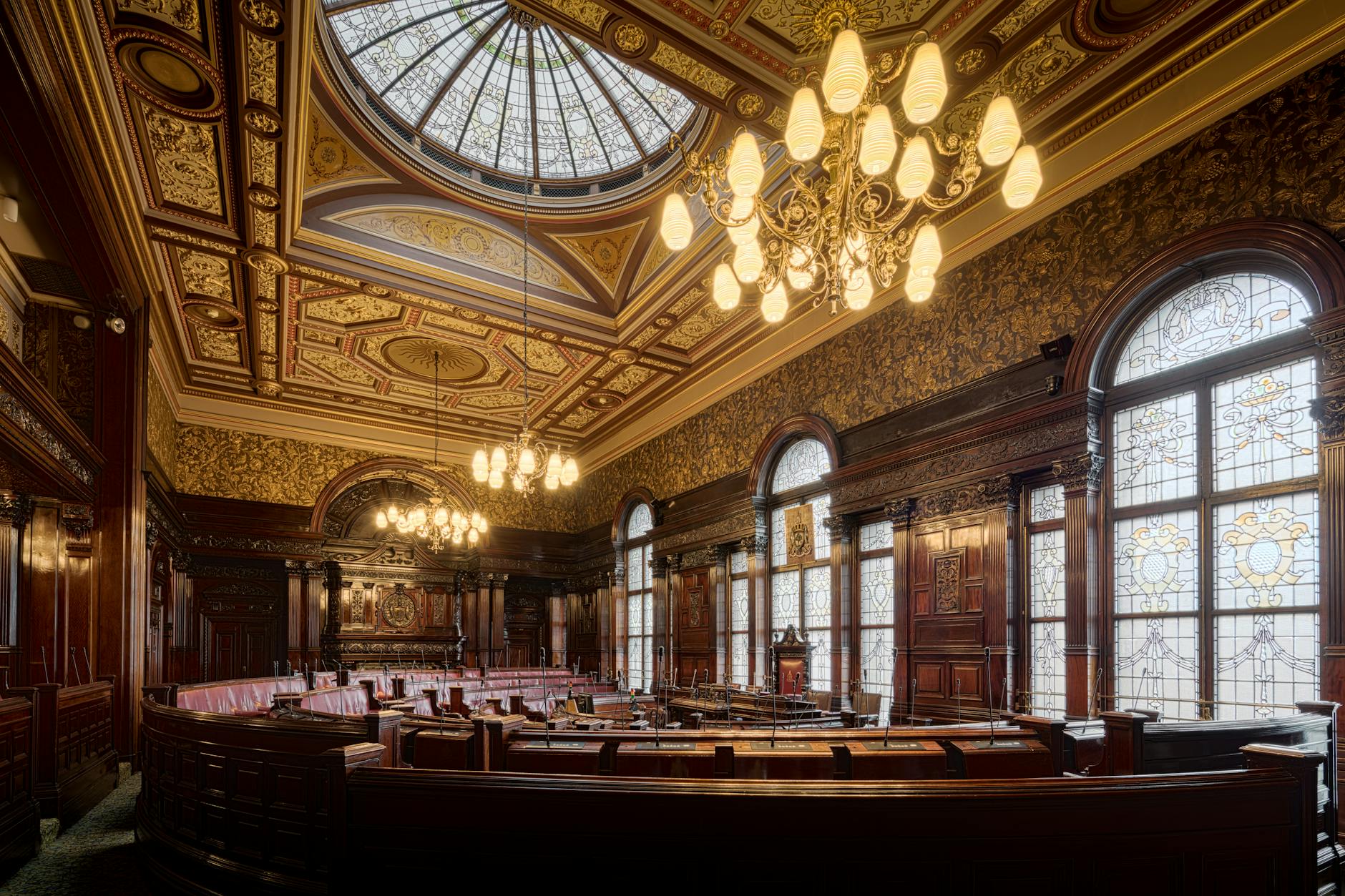 Elegant interior of Glasgow City Chambers featuring intricate details and stained glass windows.